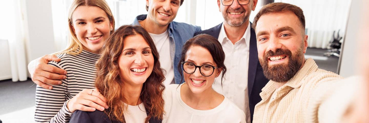 Sechs Kaufland-Mitarbeiter posieren zum Gruppenbild im Büro.